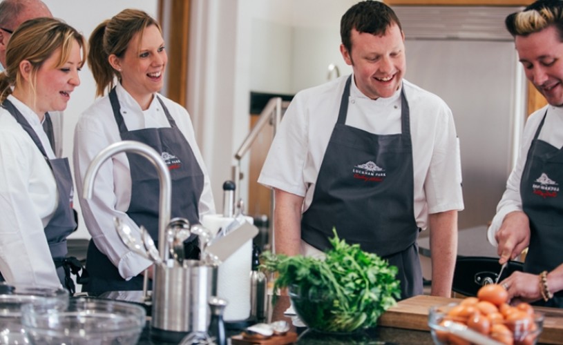 People in chef's whites and aprons at Lucknam Park Cookery School